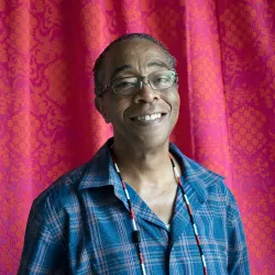 A man wearing glasses and smiling into the camera